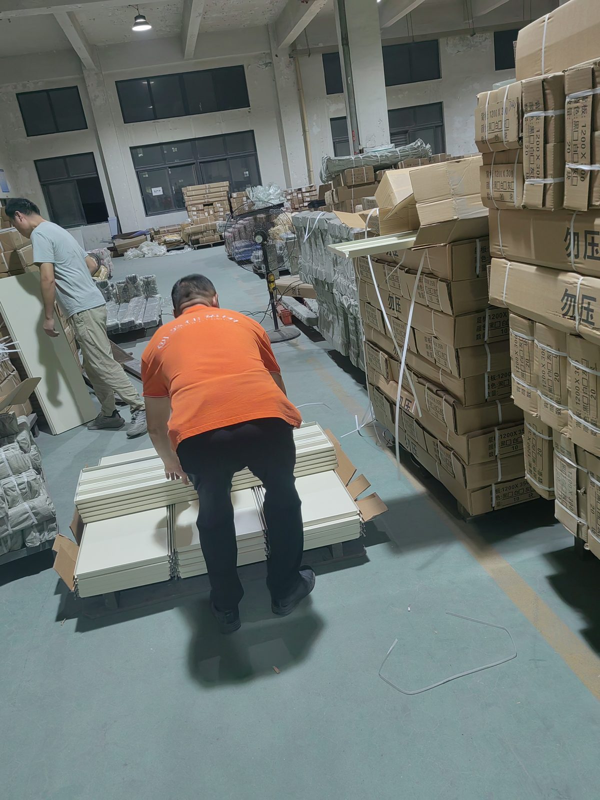 Xingye worker manually screening unshipped shelf boards in the factory warehouse