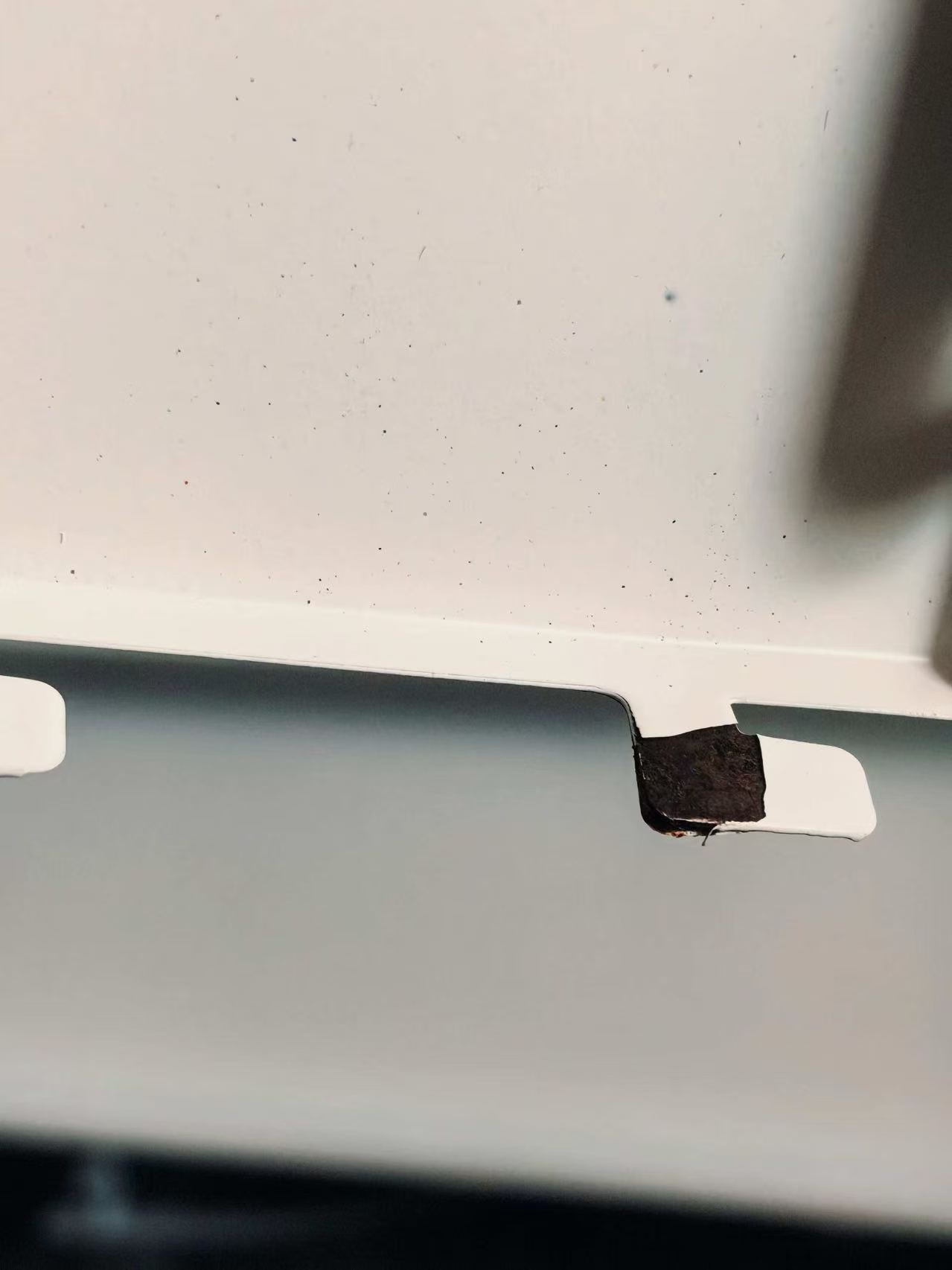 Peeling powder coating observed on a metal retail shelf